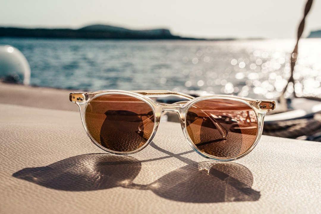 Gafas de sol con lentes marrones sobre una superficie junto al mar